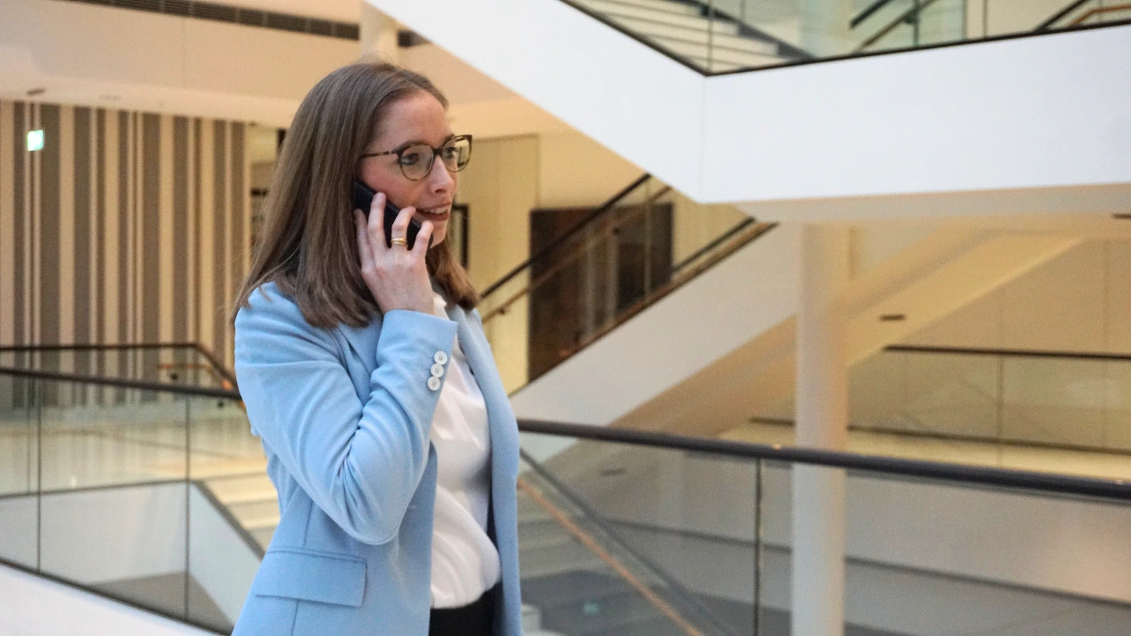 Anna Bauseneick telefoniert mit ihrem Handy im Foyer des Niedersächsischen Landtages.